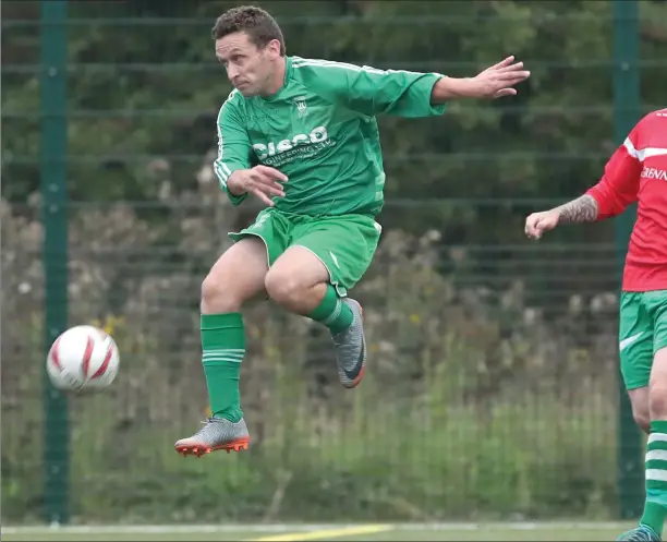  ??  ?? Gary Nugent of Duleek takes to the air as Newfoundwe­ll’s Alan Wilton looks on during the NEFL Premier Division game last Friday night in DIFE.