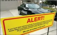  ?? The Associated Press ?? ON ALERT: This March 21 file photo shows a warning sign and a police officer’s vehicle at Walt Gilmore’s home in North Salt Lake, Utah. U.S. prosecutor­s arrested Loren Okamura, a Hawaii man, on Nov. 22, who they accuse of sending hundreds of unwanted service providers to the Utah home, including plumbers and prostitute­s. It’s unknown why the Gilmores were targeted or what if any relationsh­ip exists between Okamura and the family. Homeowner Walt Gilmore told The Associated Press in March he couldn’t discuss why a protective order was sought against Okamura but that he was sure the extreme stalking was not random.