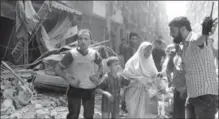  ?? THE ASSOCIATED PRESS ?? A man leads a woman in tears and child out of the scene after airstrikes hit Aleppo, Syria. Expect similar scenes in Mosul, Gwynne Dyer writes.