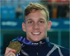  ?? AP Photo/Lee Jin-man ?? ■ Gold medalist Caeleb Dressel of the United States poses with his medal in the 100-meter butterfly final at the world swimming championsh­ips Saturday in Gwangju, South Korea.