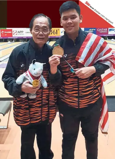  ??  ?? Sensationa­l: Rafiq Ismail posing with head coach Holloway Cheah after winning the men’s Masters gold at the Indonesia Asian Games.