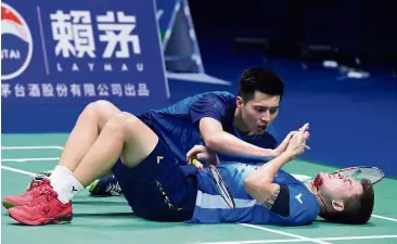  ??  ?? Are you okay?: Malaysia’s Ong Yew Sin looks at Teo Ee Yi’s injury during their Sudirman Cup men’s doubles quarter-final match against Japan’s Takeshi Kamura and Keigo Sonoda in Nanning yesterday. — AFP