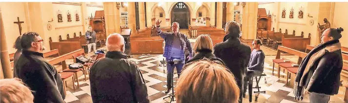  ??  ?? Für das Requiem-Konzert probt der Chor Altodijo in der Hilfarther Pfarrkirch­e mit Chorleiter Johannes Fell und Komponist (am Klavier) Thomas Hansen.
RP-Foto: Jürgen Laaser