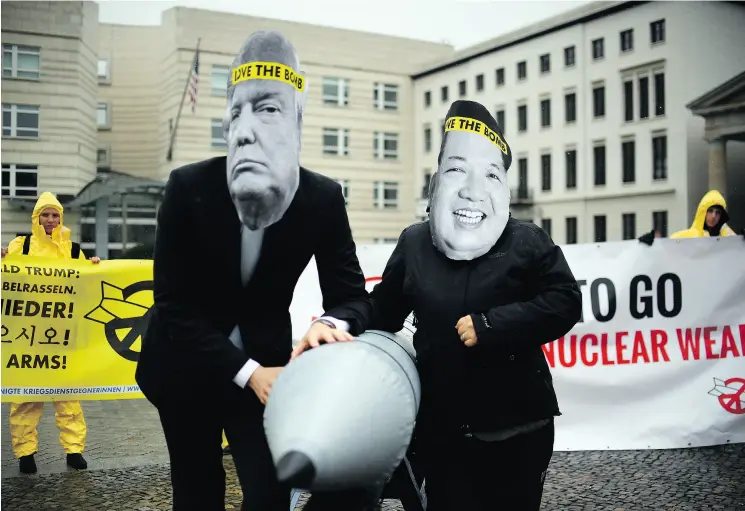  ?? BRITTA PEDERSEN / DPA FILES ?? Activists from the Internatio­nal Campaign to Abolish Nuclear Weapons don masks of U. S. President Donald Trump and North Korean leader Kim Jong Un during a protest last month in Berlin. In winning the Nobel Peace Prize earlier this month, the group was...