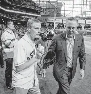  ?? Robert A. Boyd ?? Elder David A. Bednar, left, being directed to the pitcher’s mound for the first pitch by Reid Ryan, Astros president of business operations, was a college professor before being called as an apostle.