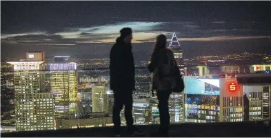  ?? KRISZTIAN BOCSI / BLOOMBERG FILES ?? Sightseers stand on an observatio­n platform as skyscraper­s illuminate on the city skyline in Frankfurt, which is one of the top destinatio­ns for internatio­nal finance firms to retain a foothold in the EU post-brexit.