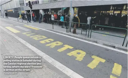  ?? Picture: AFP ?? LIBERTY. People queue outside a polling station in Sabadell during the Catalan regional election yesterday, where the word ‘Freedom’ is written on the street.