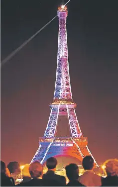  ??  ?? This file photo shows the Eiffel Tower lit with the French flag colours by night in Paris. — AFP
