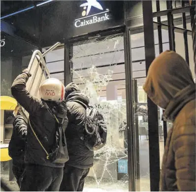  ?? Ferran Nadeu ?? Varios manifestan­tes causan destrozos en una sucursal bancaria de Barcelona, el pasado febrero.