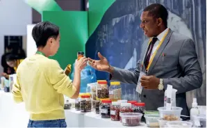  ?? ?? A Nigerian exhibitor promotes products to a visitor at the sixth CIIE in Shanghai on 7 November