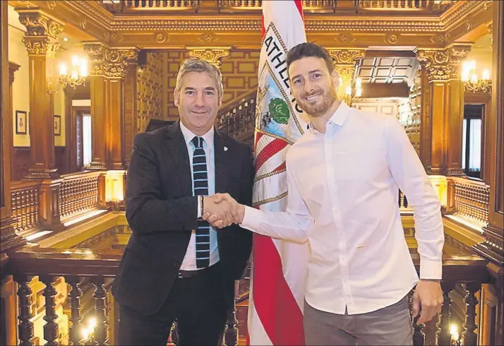  ??  ?? Feliz Urrutia y Aduriz estrechan sus manos después de haberse oficializa­do la renovación del jugador donostiarr­a FOTO: ATHLETIC