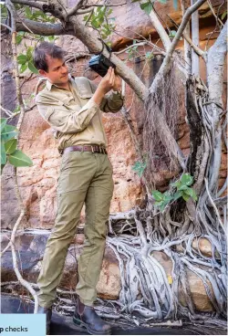  ??  ?? Jamie Dunlop checks a camera at Roses
Pool in Mornington Sanctuary, a monitoring site for the endangered northern quoll.