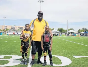  ?? EMMETT HALL/CORRESPOND­ENT ?? Jaden Joselin, left, Coach Johnny Brown and Donte Findeson take a moment to savor their thrilling six-overtime 12-6 victory over Coconut Creek at the Tamarac Sports Complex. Joselin ended the marathon effort with a six-yard touchdown run.