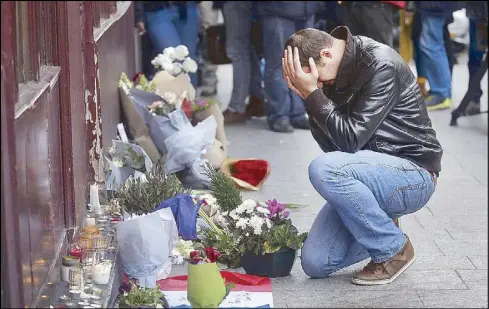  ?? REUTERS ?? A man grieves in front of a makeshift memorial for the victims of terror attacks outside Le Carillon restaurant in Paris Saturday.