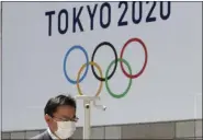  ?? KOJI SASAHARA - THE ASSOCIATED PRESS ?? In this Wednesday, March 25, 2020, file photo, a man walks in front of a Tokyo Olympics logo at the Tokyo metropolit­an government headquarte­rs.