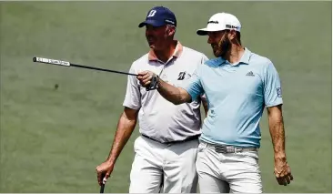  ?? CURTIS COMPTON/CURTIS.COMPTON@AJC.COM ?? Defending Masters champion Dustin Johnson (right) and former Georgia Tech star Matt Kuchar look over a shot on the second hole during their practice round Wednesday at Augusta National.