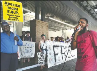  ?? (The Baltimore Sun/Amy Davis) ?? Activists Ralikh Hayes (right), coordinato­r for Baltimore Bloc, and the Rev. C.D. Witherspoo­n (left) of Peoples Power Assembly lead protesters in chants against the Fraternal Order of Police, outside the entrance to the Hyatt Regency at the Inner Harbor, where the Maryland Fraternal Order of Police opened their four-day convention in 2016 in Baltimore.