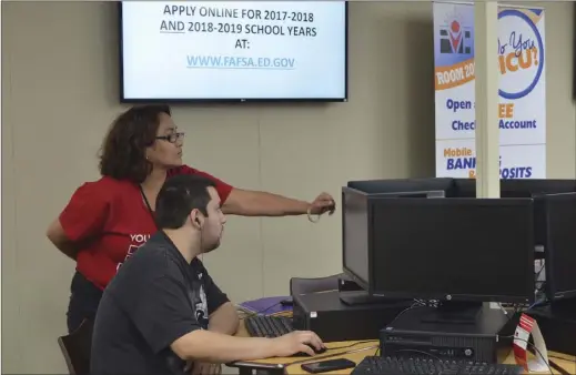  ?? JULIO MORALES PHOTO ?? Imperial Valley College graphic design student Rick Saldivar receives help from financial aid specialist Alma Orozco at the campus’ financial aid computer lab on March 12.