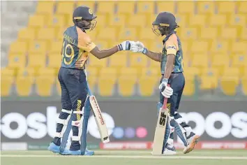  ?? — AFP ?? Sri Lanka’s Wanindu Hasaranga de Silva (L) and Sri Lanka’s Pathum Nissanka fist bump after Hasaranga’s boundary shot during the ICC Twenty20 World Cup match against Ireland at the Sheikh Zayed Stadium in Abu Dhabi.