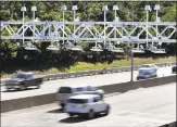  ?? Associated Press ?? Cars pass under toll sensor gantries hanging over the Massachuse­tts Turnpike in Newton, Mass.