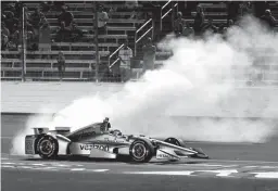  ?? Associated Press ?? Will Power, of Australia, does doughnuts at the finish line as fans watch following his win in the IndyCar auto race Saturday at Texas Motor Speedway in Fort Worth, Texas.