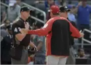  ?? BILL KOSTROUN — ASSOCIATED PRESS ?? Reds manager Bryan Price talks with umpire Shane Livensparg­er, left, and Jerry Layne during the seventh inning of Sunday’s game at Citi Field in New York.