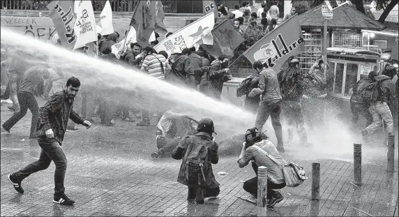  ?? ASSOCIATED PRESS ?? Riot police deter demonstrat­ors with water cannons and tear gas after protests were banned in Soma, Turkey. Unrest began after a mine collapse and fire on Tuesday led to the country’s worst industrial accident, killing at least 301.