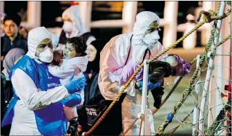  ?? — THE ASSOCIATED PRESS ?? Rescuers help children to disembark in Pozzallo, Italy, on Monday, as European leaders grappled with how to respond to the recent migrant crisis following a weekend sea disaster that left at least 700 feared drowned.