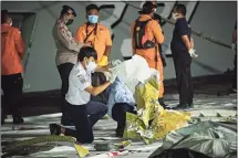  ?? Ed Wray / Getty Images ?? Indonesian investigat­ors examine debris from Sriwijaya Air flight SJ182 on Sunday in Jakarta, Indonesia.