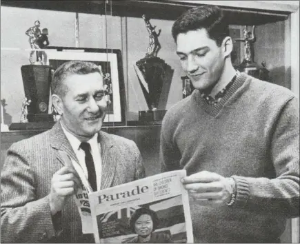  ?? READING EAGLE ?? Kutztown coach John Silan, left, and Dick Braucher look at Parade Magazine after Braucher was named to its All-America boys basketball team.