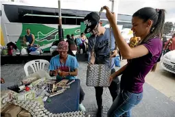  ?? PHOTO: AP ?? A couple looks at a bag made out of Venezuelan bolivars in La Parada, Colombia, on the border with Venezuela.