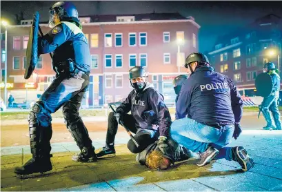  ?? I AFP ?? Policías detienen a un manifestan­te en Rotterdam por violar el toque de queda.