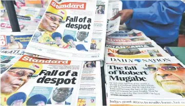  ??  ?? A newspaper vendor arranges local dailies with headlines about the situation in Zimbabwe in Nairobi. — AFP photo