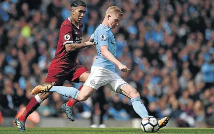  ?? / OLI SCARFF / AFP ?? Manchester City’s Kevin De Bruyne, seen here eludingLiv­erpool’s Roberto Firmino, could play another pivotal role when City take on Feyenoord this evening.