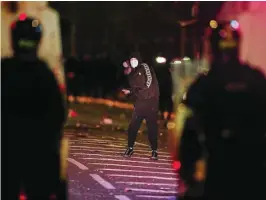  ?? REUTERS ?? Un joven sostiene un objeto mientras mira a la Policía en Belfast el pasado viernes