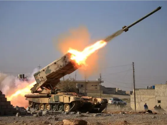  ?? (Alaa al-Marjani/Reuters) ?? Iraqi soldiers launch a rocket towards Isis fighters near the Ghazlani military complex, south of Mosul