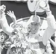  ?? MICHAEL CONROY/AP ?? Helio Castroneve­s celebrates with the traditiona­l bottle of milk after winning the Indianapol­is 500 on May 30 at Indianapol­is Motor Speedway.