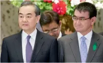  ?? — AP ?? Wang Yi and Taro Kono before the start of Japan-China high-level economic dialogue in Tokyo on Monday.