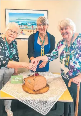  ??  ?? Cutting the celebrator­y cake marking 85 years, from left, Gail Martin, Trish McConachie, (Waihi Beach president) and Eleanor Burns.