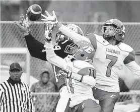  ?? MATT BUTTON/BALTIMORE SUN MEDIA GROUP ?? Edgewood's Monzel Ware, front, and Chance Singleton, right, can’t prevent Milford Mill receiver Ugo Obasi from making a catch during Saturday’s Class 3A North region final.