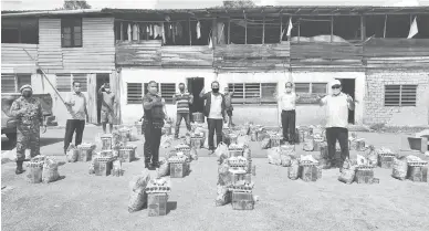  ??  ?? BAKUL PEMAKAI: Proses ngagihka bakul pemakai ngagai pernaak ba Rumah Papit, SUngai Kuap, Nyelong Sarikei ari Palan Servis DUN Repok.