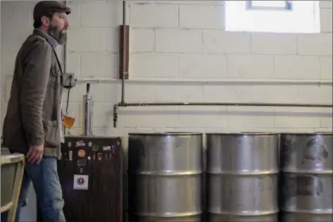  ?? ERIC BONZAR — THE MORNING JOURNAL ?? Brewmaster Chris Kambouris grabs a glass of his handcrafte­d beer in what is to become the brew room of his and business partner Fred Lozano Jr.’s Bascule Brewery and Public House, 1397 Colorado Ave., in Lorain.