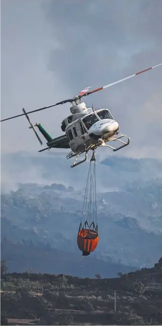  ?? ?? A firefighti­ng helicopter tackles a blaze in central Portugal. Picture: AFP