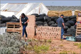  ?? AP ?? Taos County officials survey a compound in Amalia, N.M. Investigat­ors said that a body found there has been identified as a missing Georgia boy whose father is accused of kidnapping him and performing purificati­on rituals on the severely disabled child.