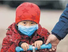  ?? FOTO: DPA ?? Schutzmask­e gegen Smog in China. Luftversch­mutzung kann bei Kindern Lugenentzü­ndung auslösen.