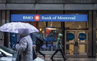  ?? AARON VINCENT ELKAIM, THE CANADIAN PRESS ?? People walk by a Bank of Montreal branch in Toronto’s financil district on Tuesday.