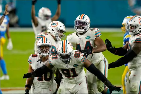  ?? AP PHOTO/LYNNE SLADKY ?? Miami Dolphins defensive end Emmanuel Ogbah (91) and his teammates celebrate after a play during the second half of an NFL football game against the Los Angeles Chargers, Sunday, in Miami Gardens, Fla.