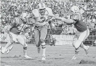  ?? AP PHOTO ?? Buffalo Bills running back O.J. Simpson carries the ball as Baltimore Colts linebacker Mike Curtis pulls his jersey during an NFL game on Oct. 12, 1975. Simpson died Wednesday at age 76.