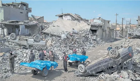  ?? AP ?? Destrucció­n. En medio de los escombros, residentes de Mosul llevan, este viernes, los cuerpos de varios civiles muertos en bombardeos.