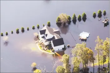  ?? Alex Wroblewski / Bloomberg ?? A home surrounded by floodwater is seen in this aerial photograph taken above Kinston, N.C., on Friday. Record floods cover much of eastern North Carolina in the wake of Hurricane Florence, and the waters are still rising.